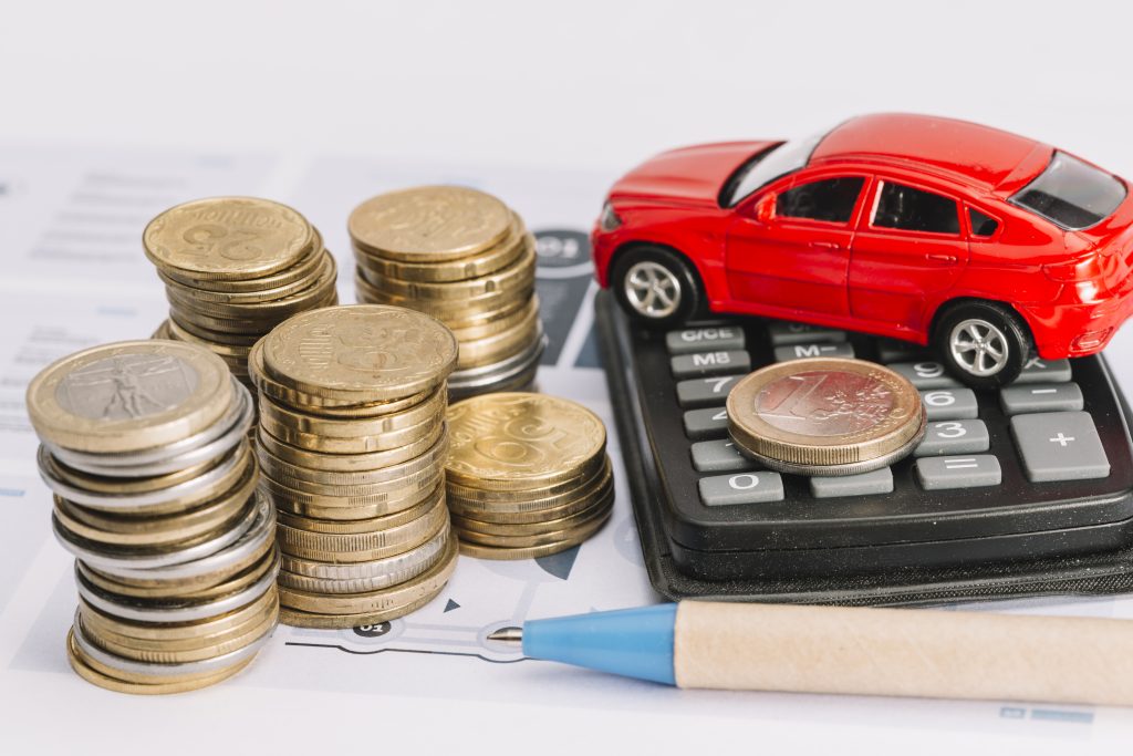 Rahaa, leluauto, laskin ja kynä. Autohuollon rahoitus